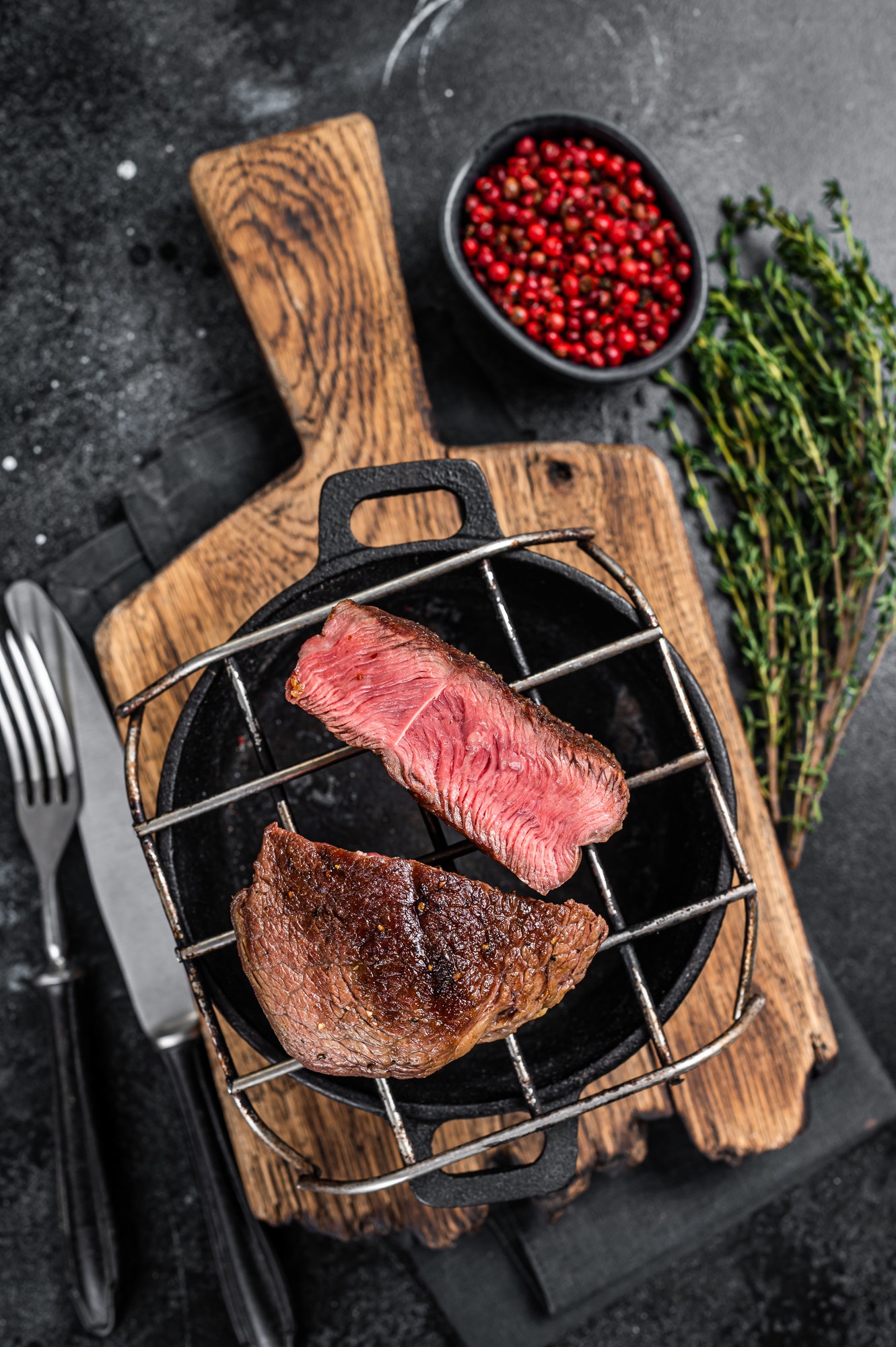 Beef tenderloin steak is grilled on a grill pan. Black background. Top view