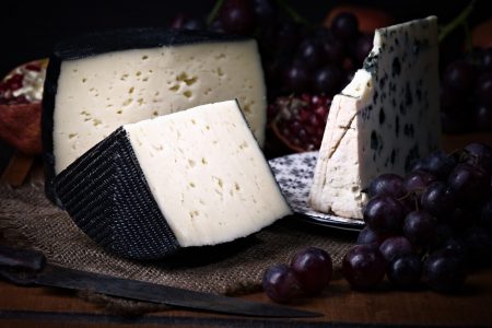 Spanish sheep cheese and Roquefort cheese with grape bodegon with classic light on wood